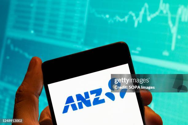 In this photo illustration, the Australia and New Zealand Banking Group Limited, commonly called the ANZ logo seen displayed on a smartphone with an...