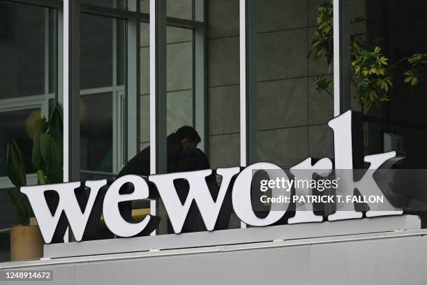The WeWork logo is displayed outside of an office space rental location in Santa Monica, California on March 20, 2023.