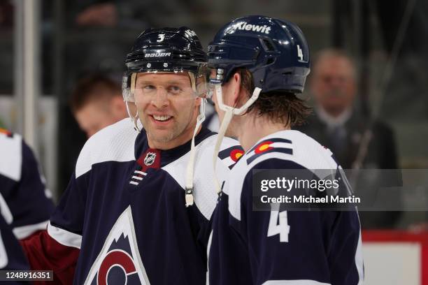 Jack Johnson of the Colorado Avalanche talks with Bowen Byram of the Colorado Avalanche before a game against the Chicago Blackhawks at Ball Arena on...