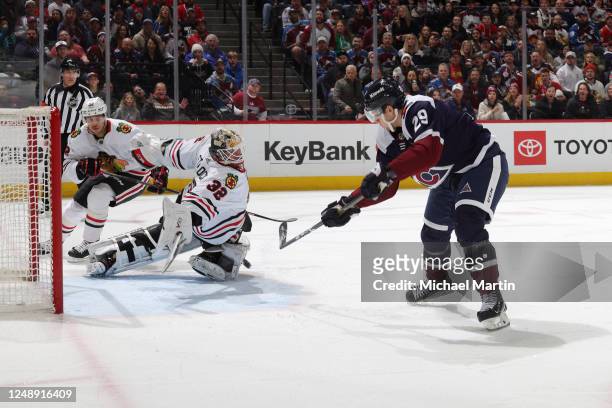Alex Stalock of the Chicago Blackhawks blocks a shot by Nathan MacKinnon of the Colorado Avalanche during the first period at Ball Arena on March 20,...