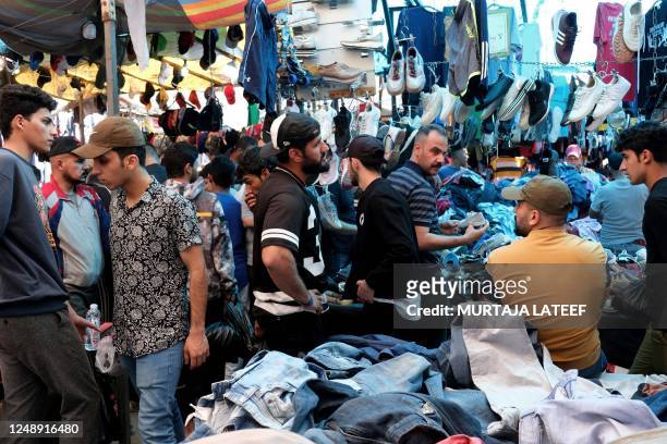 People shop at a flea market in Baghdad on March 10, 2023. - In many parts of Iraq, scarred by decades of conflict, peaceful rhythms are gradually...