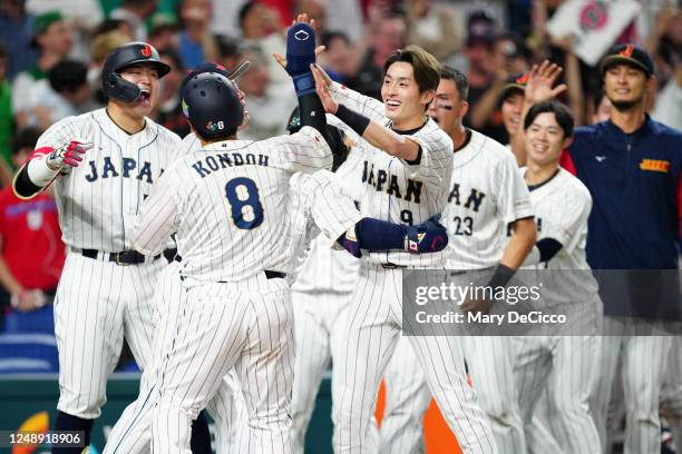 Kensuke Kondoh of Team Japan celebrates with teammates after scoring on a three-run home run hit by Masataka Yoshida in the seventh inning during the...