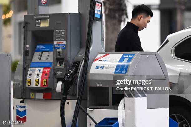 Customer pumps gasoline into a vehicle at a Chevron gas station in Santa Monica, California on March 20, 2023.