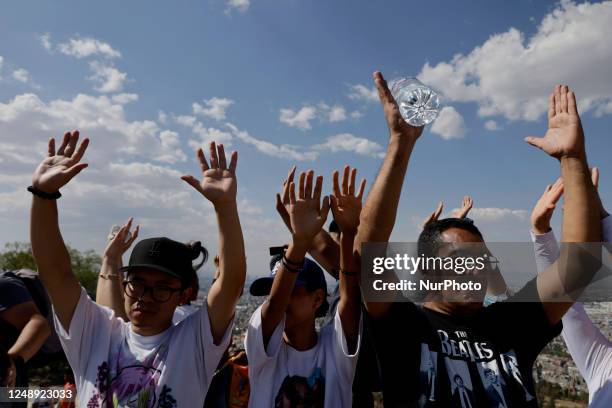 Inhabitants of Mexico City raise their arms to ''charge themselves with positive energy'' during their visit to the Cerro de la Estrella...