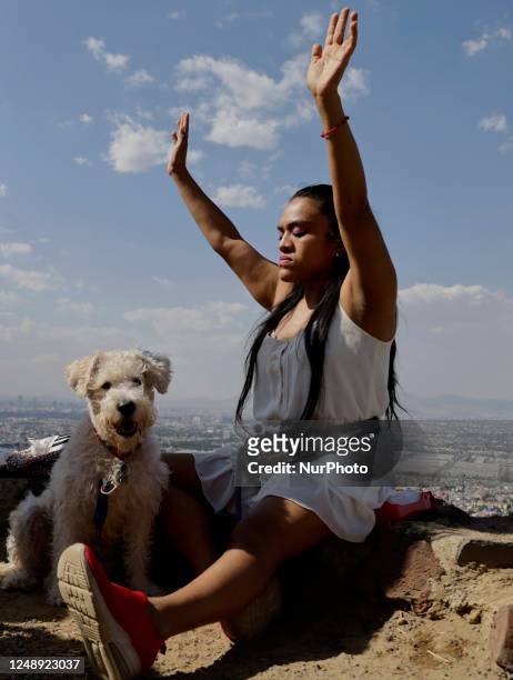 Resident of Mexico City accompanied by her dog raises her arms to ''charge herself with positive energy'' during her visit to the Cerro de la...