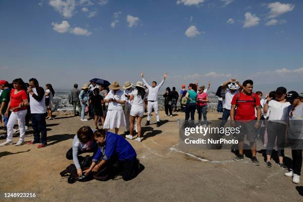 Inhabitants of Mexico City raise their arms to ''charge themselves with positive energy'' during their visit to the Cerro de la Estrella...