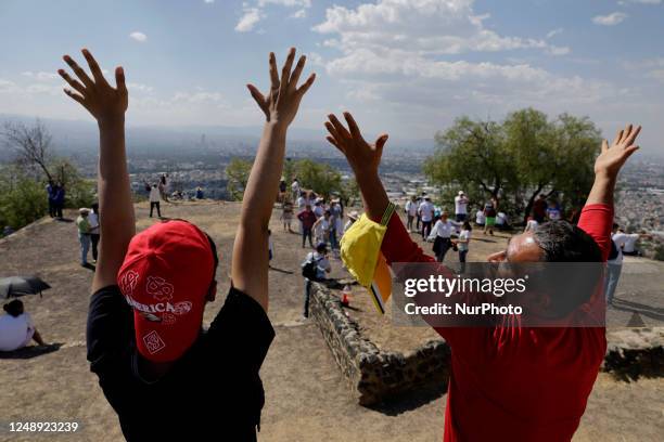 Inhabitants of Mexico City raise their arms to ''charge themselves with positive energy'' during their visit to the Cerro de la Estrella...