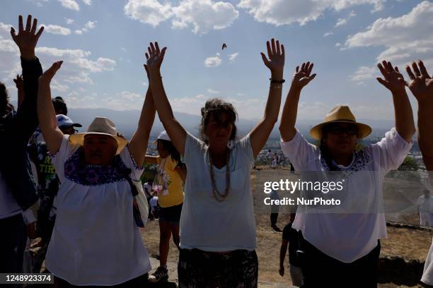 Inhabitants of Mexico City raise their arms to ''charge themselves with positive energy'' during their visit to the Cerro de la Estrella...