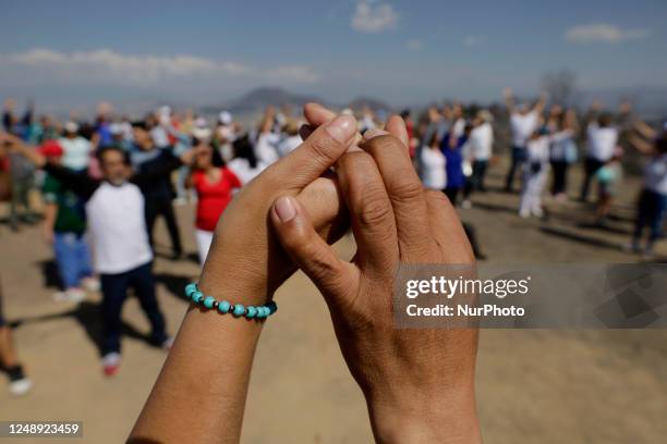 Inhabitants of Mexico City raise their arms to ''charge themselves with positive energy'' during their visit to the Cerro de la Estrella...