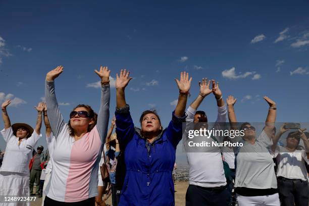 Inhabitants of Mexico City raise their arms to ''charge themselves with positive energy'' during their visit to the Cerro de la Estrella...