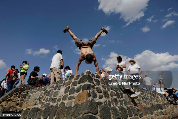 An inhabitant of Mexico City performs acrobatics after ''charging himself with positive energy'' during his visit to the Cerro de la Estrella...