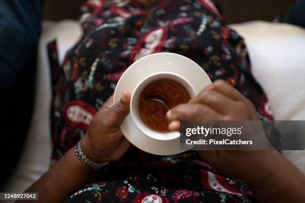 direct boven grootmoeder die kop thee beweegt - africa cup of nations 2010 abuja stockfoto's en -beelden