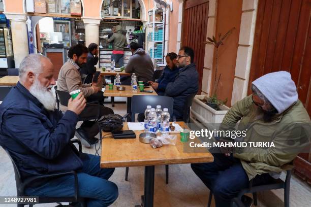 In this picture taken on March 16 men drink coffee outside a cafe in Tripoli. - Italy left a deep cultural mark on Libya, the only Arab country it...