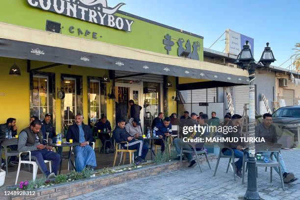 In this picture taken on March 17 people sit outside a coffee shop in Tripoli. - Italy left a deep cultural mark on Libya, the only Arab country it...