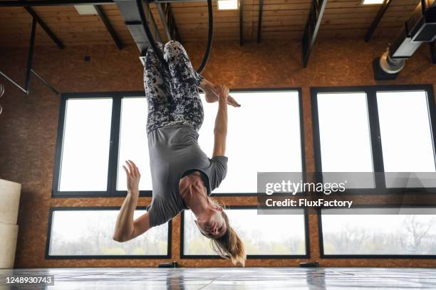 flexible woman hanging and stretching on a aerial ring - ringmaster stock pictures, royalty-free photos & images