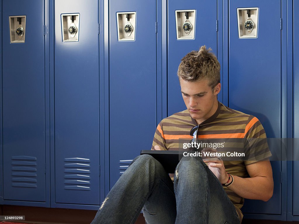 USA, Utah, Spanish Fork, School boy (16-17) using digital tablet by lockers