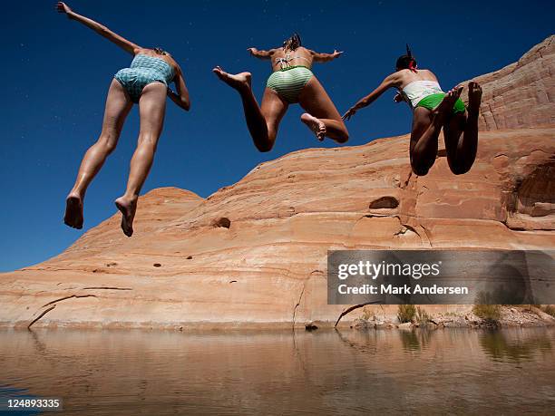 usa, utah, lake powell, three women jumping into lake - lake powell stock pictures, royalty-free photos & images