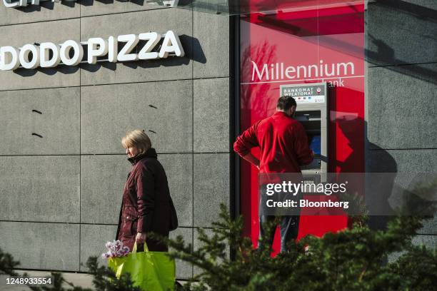 Customer uses a Millenium Bank Zao automated teller machine in the Rondo Wiatraczna shopping mall in Warsaw, Poland, on Monday, March 20, 2023....