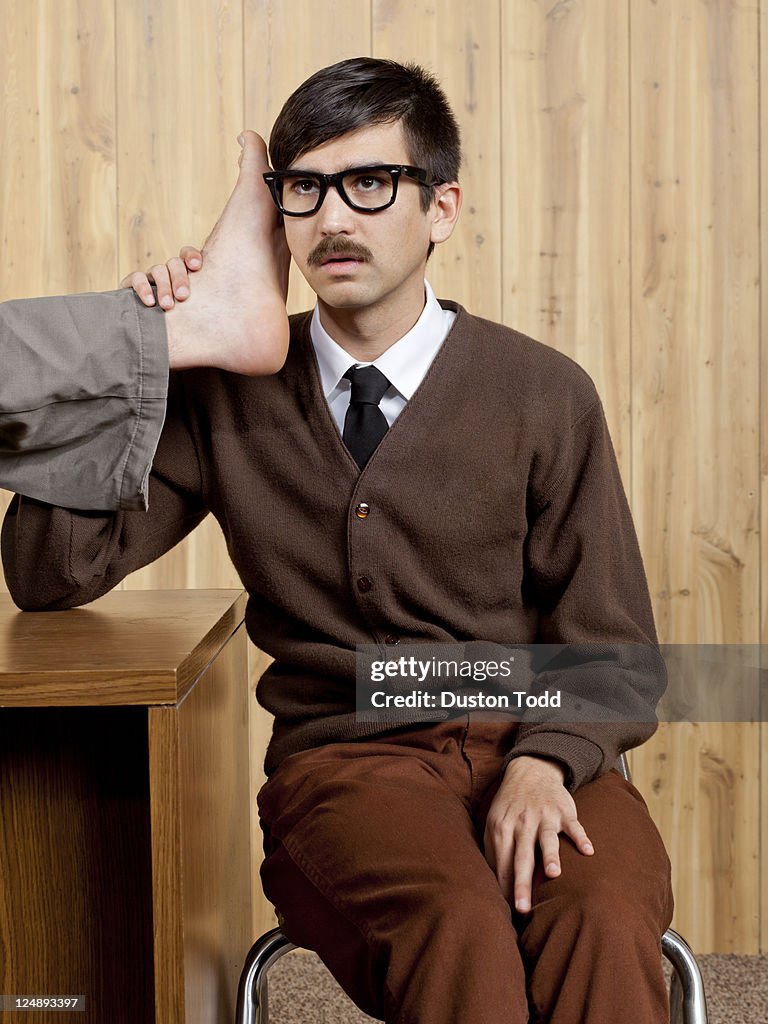 Businessman using foot phone in office