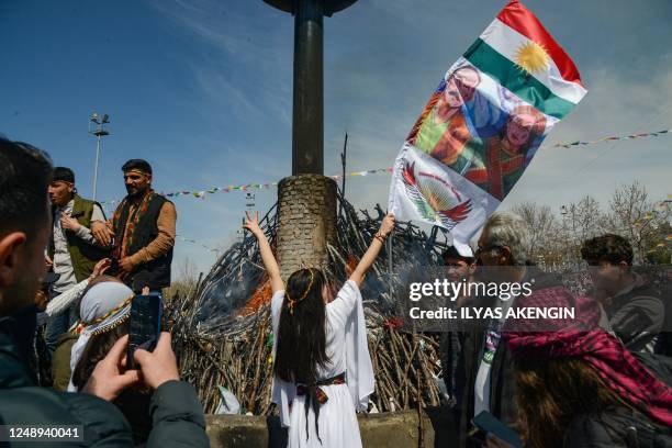 Reveller flashes the V-sign in front of a bonfire during a gathering of Turkish Kurds for Newroz celebrations, marking the Persian New Year in...