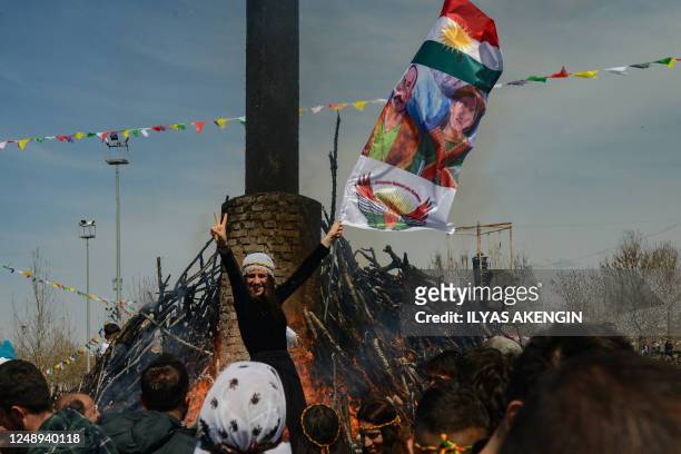 Reveller flashes the V-sign in front of a bonfire during a gathering of Turkish Kurds for Newroz celebrations marking the Persian New Year in...