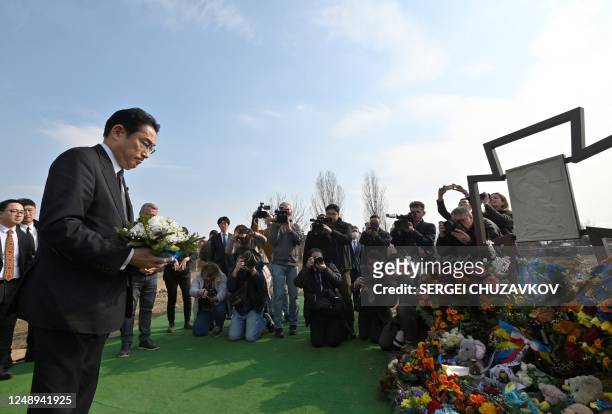 Japan's Prime Minister Fumio Kishida pays his respect at the site of a mass grave found on the grounds of the church of Saint Andrew Pervozvannoho...