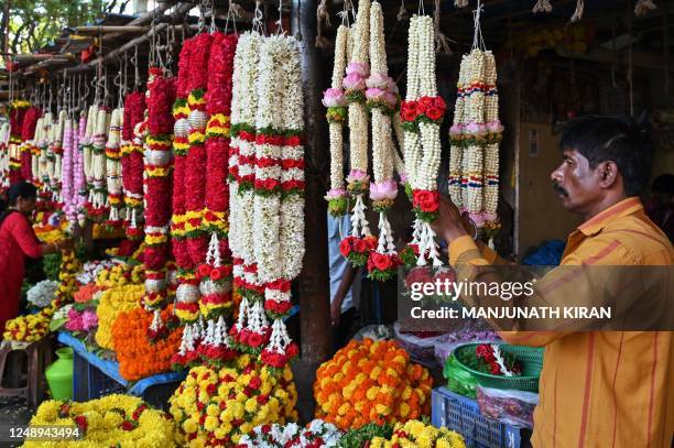 Vendor arranges flower garlands at a flower market in Bengaluru on March 21 on the eve of 'Ugadi', a festival celebrated as New Years Day by Hindus...