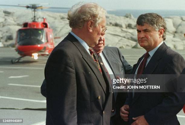 Nova Scotia Premier Russell MacLellan stands with Senator Al Graham of Nova Scotia and an unidentified official after touring by helicopter the crash...