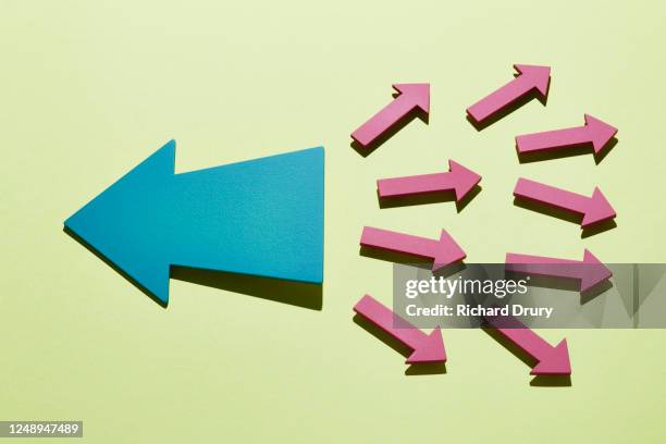 a group of small arrows moving right with a big arrow moving left - resolve conflict stock pictures, royalty-free photos & images