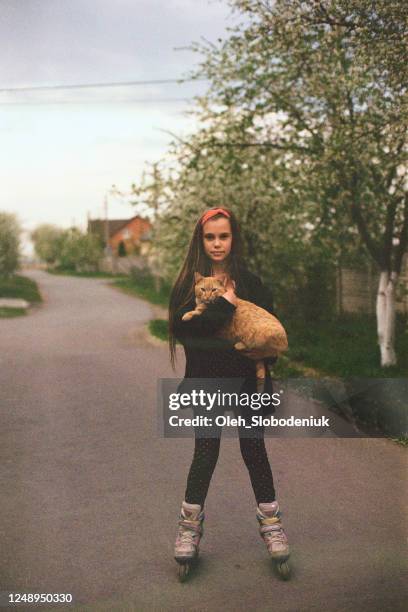 girl roller skating with cat on hands - film darchive photos stock pictures, royalty-free photos & images