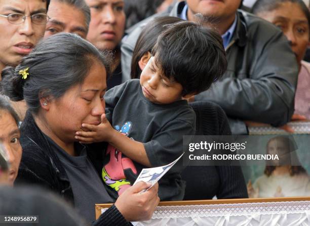 Boy comforts his mother 26 September, 2006 in Sangolqui, 60km from Quito during the funeral of his father dead Sunday in a bus accident. At least 47...