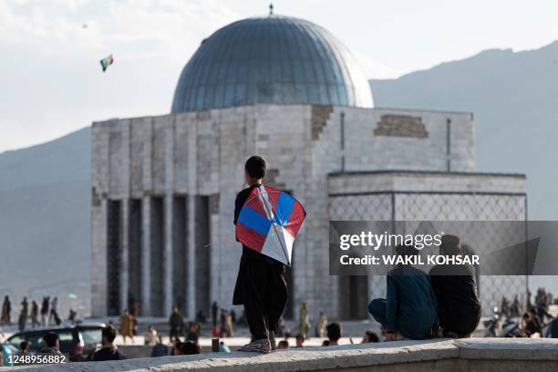 An Afghan boy holds a kite near Nadir Khan's tomb during 'Nowruz', the Persian New Year which was celebrated widely in Afghanistan before the Taliban...