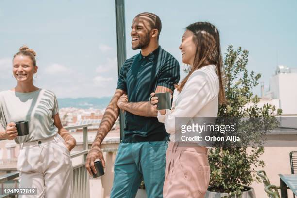 kollegen machen eine pause auf der terrasse in barcelona - building terrace stock-fotos und bilder
