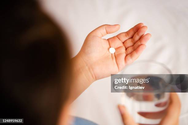 close up of the one round white pill in female hand. - dissolving stock pictures, royalty-free photos & images