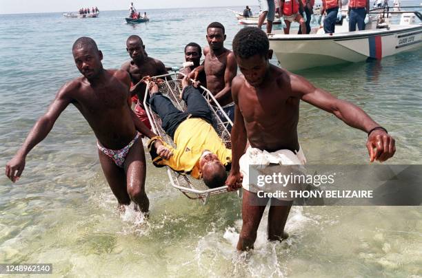 Local residents carry one of several people who drowned 08 September after an overcrowded passenger ferry sank off the Haitian coast near Monrouis,...