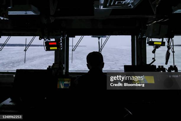 Crew member steers the US Coast Guard 'Katmai Bay' Cutter ship during ice clearing operations on St. Mary's River in Sault Sainte Marie, Michigan,...