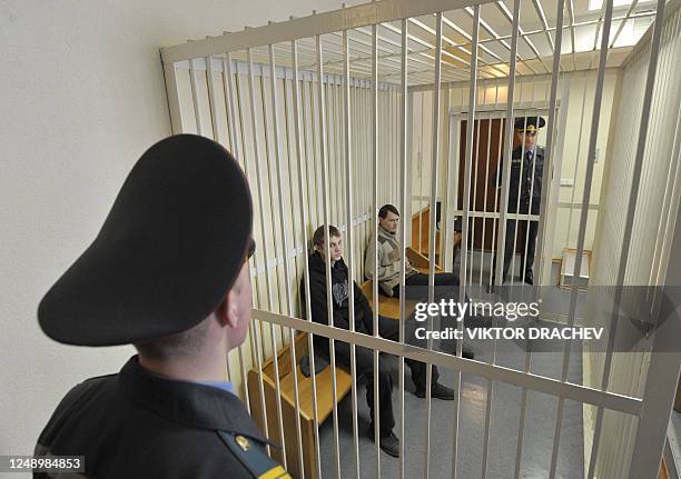 Leader of Belarus oposition movement "Molodoy front" Zmiter Dashkevich and Eduard Lobov sit inside of a guarded cage during a court hearing in Minsk...