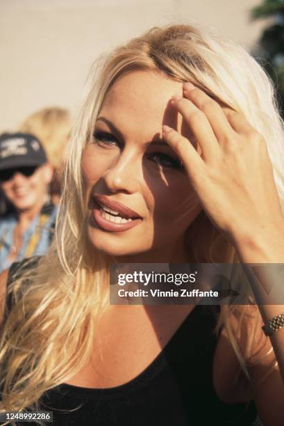 Canadian actress Pamela Anderson, wearing a sleeveless black top with a scoop neckline, attends a 'Baywatch' cast party, held on Malibu Pier in...