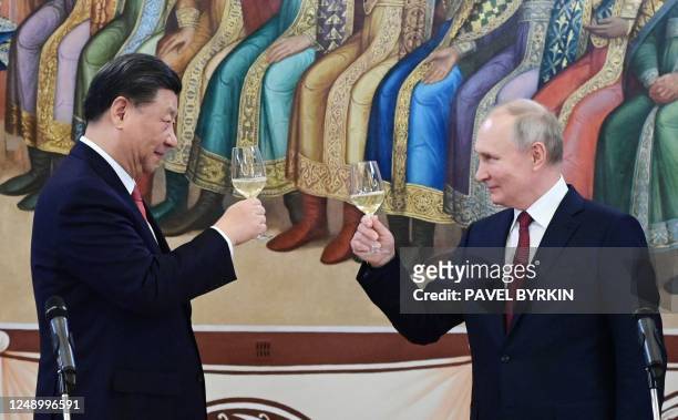 Russian President Vladimir Putin and China's President Xi Jinping make a toast during a reception following their talks at the Kremlin in Moscow on...