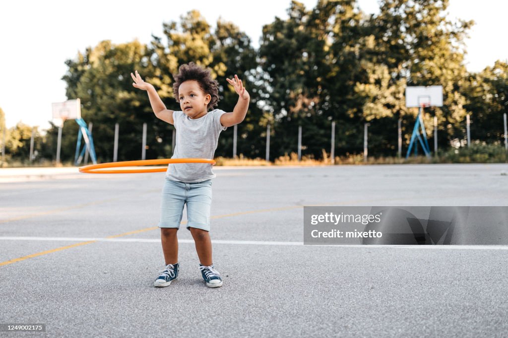 Girl with hoola hoop on playground