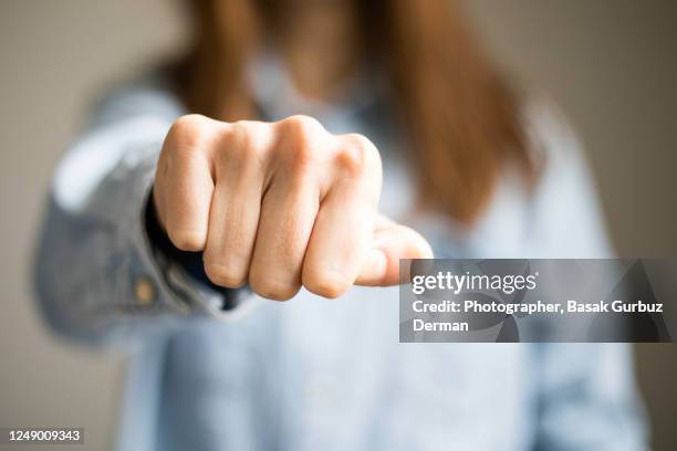 a woman clenching fist - knuckles stock pictures, royalty-free photos & images