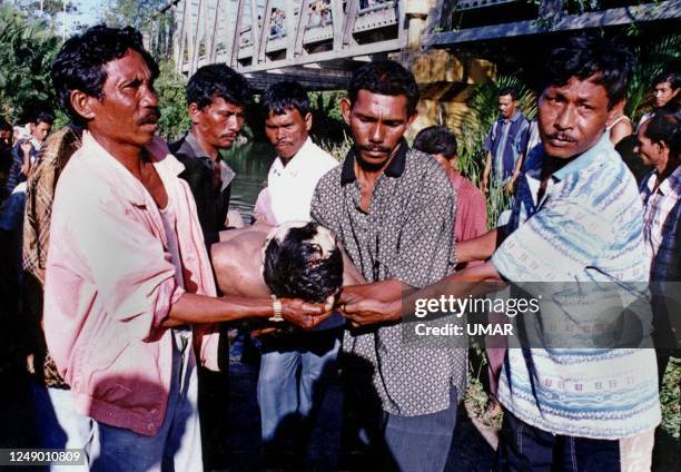 The body of Usman Abu Bakar is carried away from the Krueng Kurutoe River where he was found drowned 15 February 2001 in Lhokseumawe, in Ache...