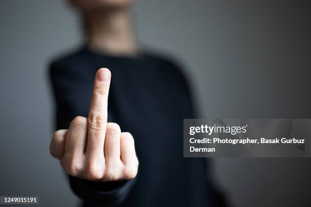 a woman's hand, making obscene gesture - doigt dhonneur stockfoto's en -beelden