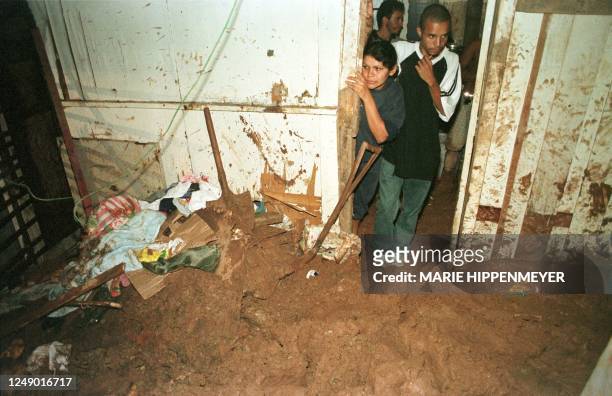Dwellers of the Campo Limpo slum in Sao Paulo, Brazil look at a mudslide which passed by their house in the south area of the city, 28 February 2000....