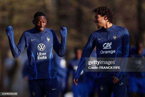 France's forward Randal Kolo Munani speaks with France's midfielder Khephren Turam before a training session in Clairefontaine-en-Yvelines on March...