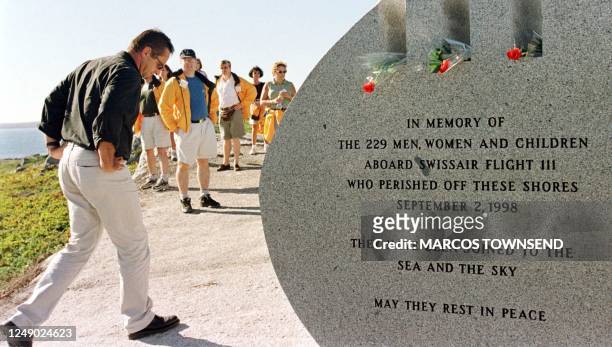 The relative of a victim in Swissair Flight 111 passes a monument just unveiled to the 229 victims in Whalesback, Nova Scotia, near Peggy's Cove 01...