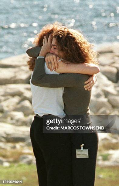 Tearful relatives of victims of the Swissair Flight 111 comfort each other during the unveiling of a monument to the 229 victims in Whalesback, Nova...