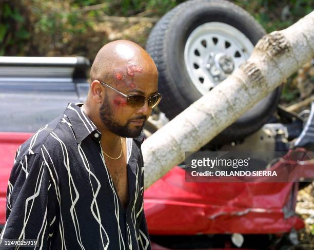 Bryan Harris, producer and friend of US rapper Lisa Lopes, looks for personal items, 26 April 2002, from the accident scene that claimed the life of...