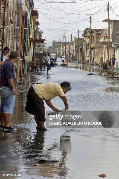 Resident of Colon, Cuba empties a bucket of water on the street 05 Novmber 2001. Una pobladora de Colon, a 180 km de La Habana, Cuba, vacia el 05 de...