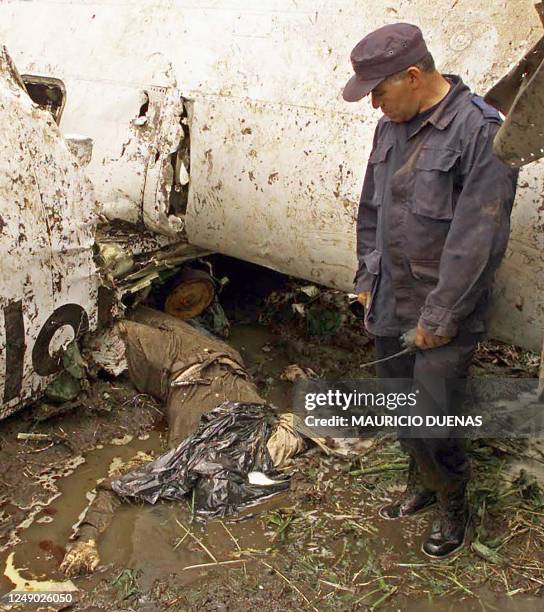 Instituto Nacional Penitenciario guard looks at an unidentified body from the helicopter accident in Guillermo Leon Valencia de Popayan Colombia, 10...